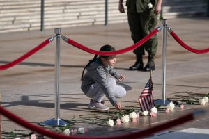 Girl placing flowers by Tomb of the Unknown Soldier. 